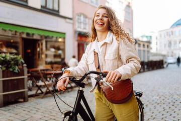 Happy woman riding bicycle at the city street outdoor. Freedom on two wheels. Active lifestyle.