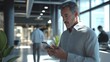 © Georgii - European man using smartphone in modern office environment with focus on technology and communication