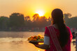 © Alexey - Chhath Puja background. Ancient Sandhya arghya day. Lady near the river to worship Surya, the sun god and his sister Chhathi Maiya