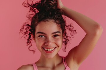 A happy woman with curly hair smiling directly at the camera