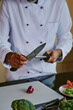 © AnnaStills - Unrecognizable male chef sharpening knife carefully while preparing ingredients