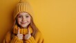 © Larisa AI - A sweet young girl in a cozy yellow knit hat and sweater gives a warm smile, with her thumbs pointing up against a matching yellow background.
