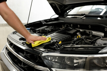 Wall Mural - Man wiping auto engine with rag at car wash, closeup