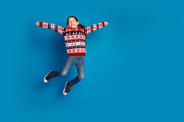 Wall Mural - Photo of cheerful cute girl wear red sweater have fun jump up christmas miracle isolated on blue color background