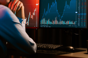 Cropped working young business trader analyzing on market stock graph database in real time screens with sideways view image at neon modern office. Concept of dynamic financial exchange rate. Gusher.