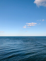 Wall Mural - seascape from kayak of clear blue ocean and white fluffy clouds and blue sky