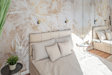 modern bedroom with textured wallpaper with pattern. bright interior of room with beige pillow and c