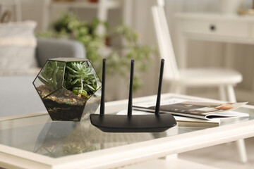 Wall Mural - Modern wi-fi router with florarium and magazines on table in living room, closeup