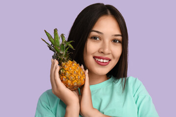 Poster - Beautiful young Asian woman with fresh pineapple on lilac background