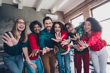 Wall Mural - Photo of attractive young people employees wave hands hello new year decoration interior corporate party office