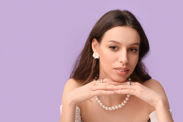 Wall Mural - Woman wearing jewelry on purple background