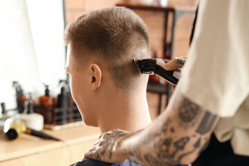 Poster - Male hairdresser trimming client's hair in barbershop, closeup