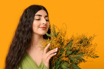 Wall Mural - Pretty young woman with bouquet of mimosa flowers on yellow background