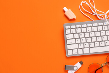 Composition with keyboard, sunglasses and flash drive on orange background. Top view