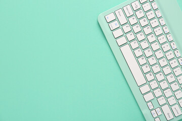 Wall Mural - Green computer keyboard on green background. Top view