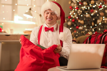 Sticker - Young Santa Claus with bag of gifts at home on Christmas eve