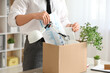 © Pixel-Shot - Fired young man packing his personal stuff in box on table in office, closeup