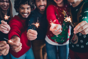 Sticker - Cropped photo of cheerful young people colleagues hold bengal light cozy christmas party decor spacious office indoors