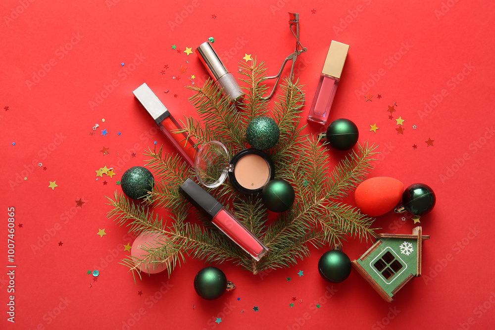 Composition with decorative cosmetics, fir branches and Christmas decorations on red background