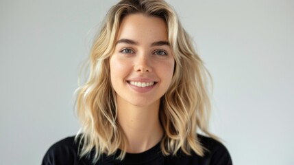 A natural light portrait photo features a young woman with wavy blonde hair and a warm smile, expressing friendliness and approachability. It's vibrant and contemporary.