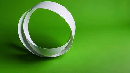 Three dimensional white ribbons are twisting and rotating on a vibrant green screen background, ideal for chroma key compositing