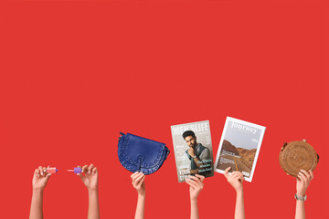 Poster - Female hands with different magazines, lip gloss and stylish bags on red background