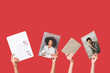© Pixel-Shot - Female hands with different magazines, newspaper and book on red background