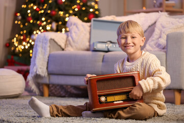 Sticker - Cute little boy with retro radio receiver at home on Christmas eve