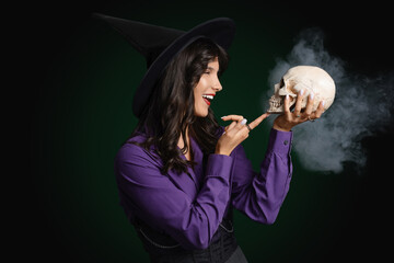 Canvas Print - Young witch with skull and smoke on dark background