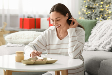 Sticker - Beautiful young woman writing Christmas letter to Santa in living room