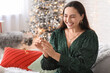 © Pixel-Shot - Beautiful young woman with Christmas sparkler in living room