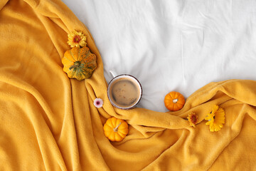 Wall Mural - Composition with cup of tasty coffee, pumpkins, flowers and soft plaid on bed