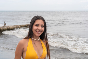 Smiling Woman Posing by the Ocean Shoreline