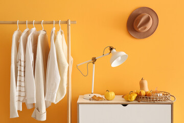 Sticker - Interior of room with autumn clothes and pumpkins