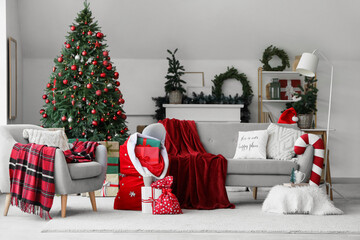 Wall Mural - Interior of light living room with sofa, Santa bag and Christmas trees