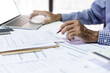 © Lek - Asian businessman reviewing document report at office working with laptop, professional lawyer reading and checking financial documents or insurance contract before sign, Close-up shot