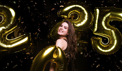 Happy gorgeous girl in stylish sexy party dress holding gold 2025 balloons, having fun at New Year's Eve Party.