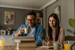 © La Famiglia - Happy family couple managing household budget, planning investment, analyzing paper utility bills, making payments and fill application forms together