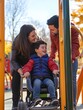 © Siriroj - Loving Family Enjoying Time Together at Accessible Playground in Autumn
