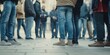 © saichon - Close-up of people standing in line, waiting for something. People stand on the street and talk to each other, their legs visible from behind.