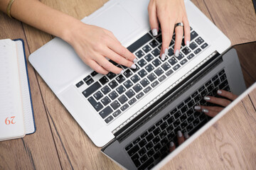 Wall Mural - The girl is typing on the keyboard. View from above.