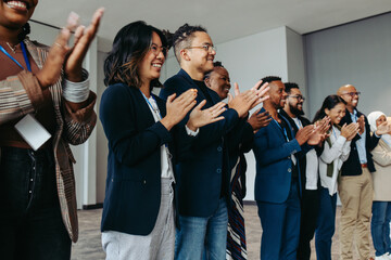 Wall Mural - diverse group of business employees applauding during a celebration event