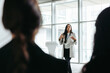 © Jacob Lund - Confident female business leader presenting in a modern office environment with colleagues listening attentively