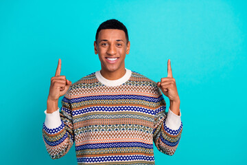 Sticker - Portrait of nice young man direct fingers up empty space wear pullover isolated on turquoise color background