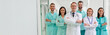 © My Ocean studio - A confident group of healthcare professionals in lab coats and scrubs standing with arms crossed in a modern hospital hallway. Ideal for concepts of teamwork, medical staff, and professional care.