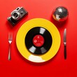 © Sanja - A creative arrangement with a vinyl record on a yellow plate, accompanied by a retro black camera and a disco ball, set against a vibrant red background. Disco party concept.