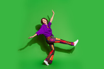 Poster - Photo portrait of funny young girl in trendy outfit flying dreamer and brown bob haircut dancer isolated on green color background