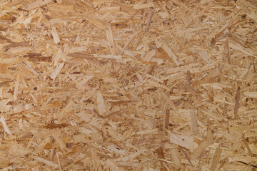 OSB board (Oriented Strand Board), showing overlapping wood fiber texture and light brown color