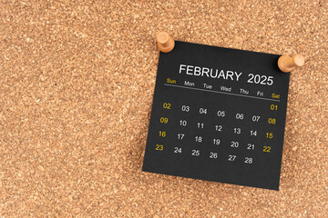 Black calendar sheet for February 2025 with thumbtack on wooden board, Position with copy space.