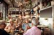 © Davor - Smiling young waitress taking order from diverse senior people at a bistro